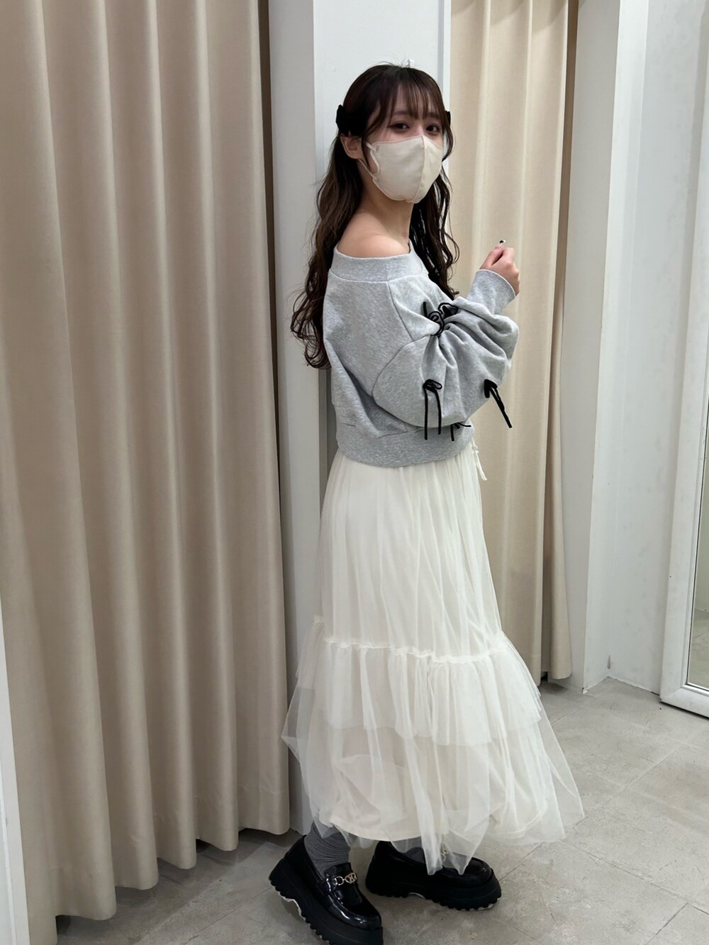 グレー系のスウェット、ホワイト系のスカート、ブラック系のローファーを着用したレディースの春コーディネートの3枚目の写真