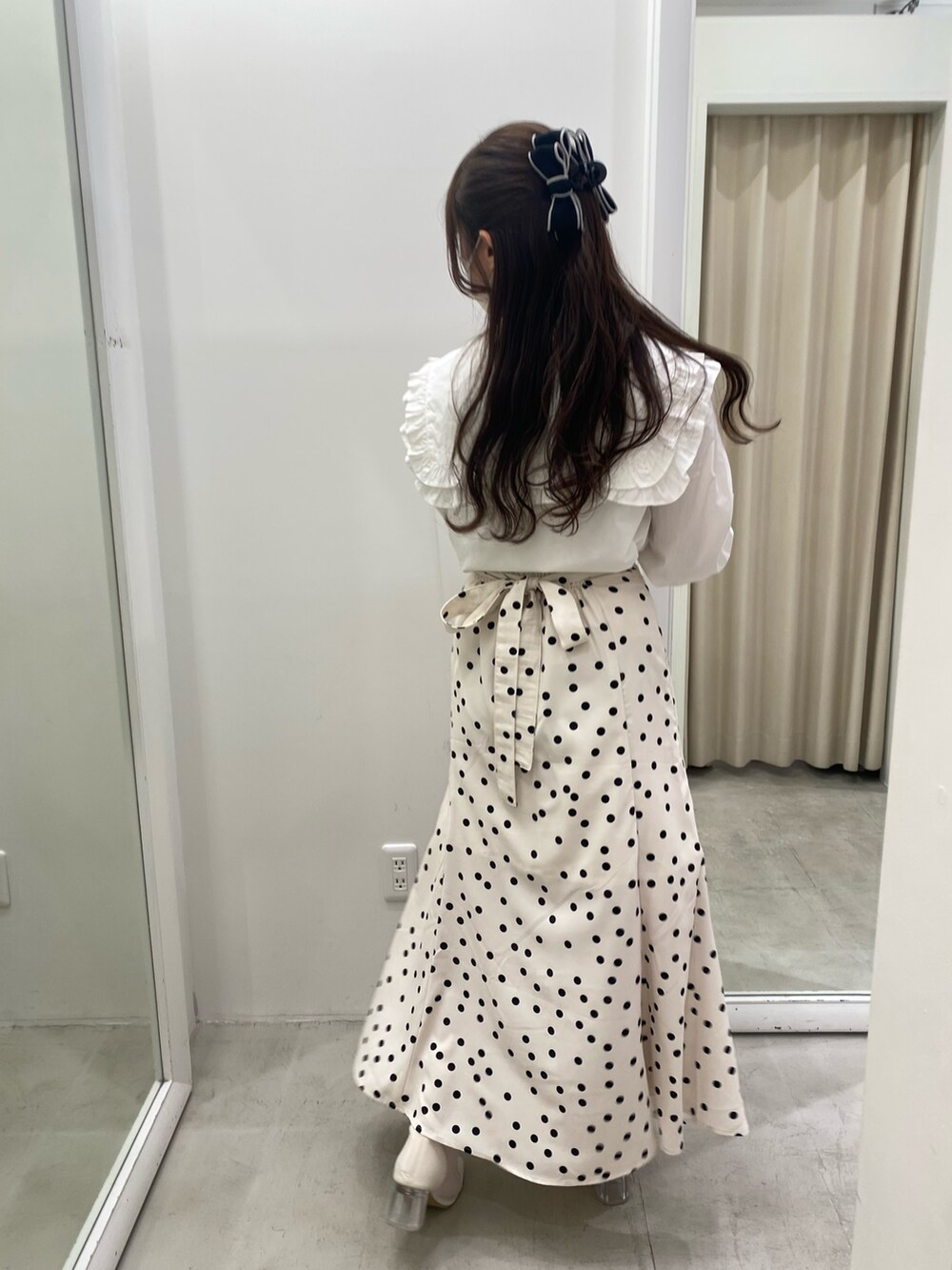 ホワイト系のシャツ/ブラウス、ホワイト系のスカート、ホワイト系のブーツを着用したレディースの春コーディネートの2枚目の写真