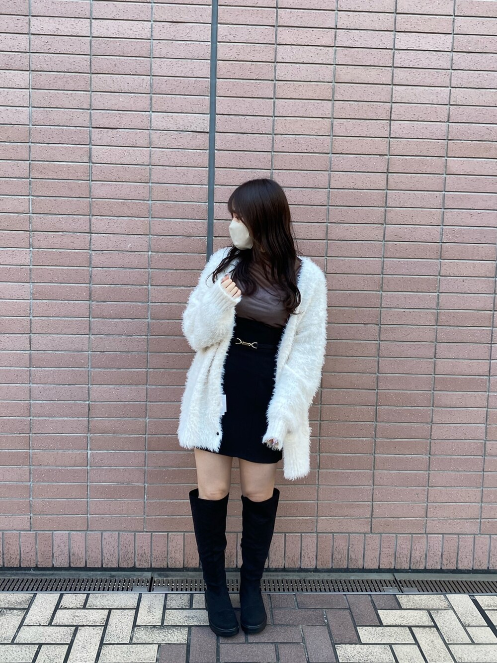 ホワイト系のカーディガン/ボレロ、ブラウン系のTシャツ/カットソー、ブラック系のスカートを着用したレディースの秋コーディネートの2枚目の写真