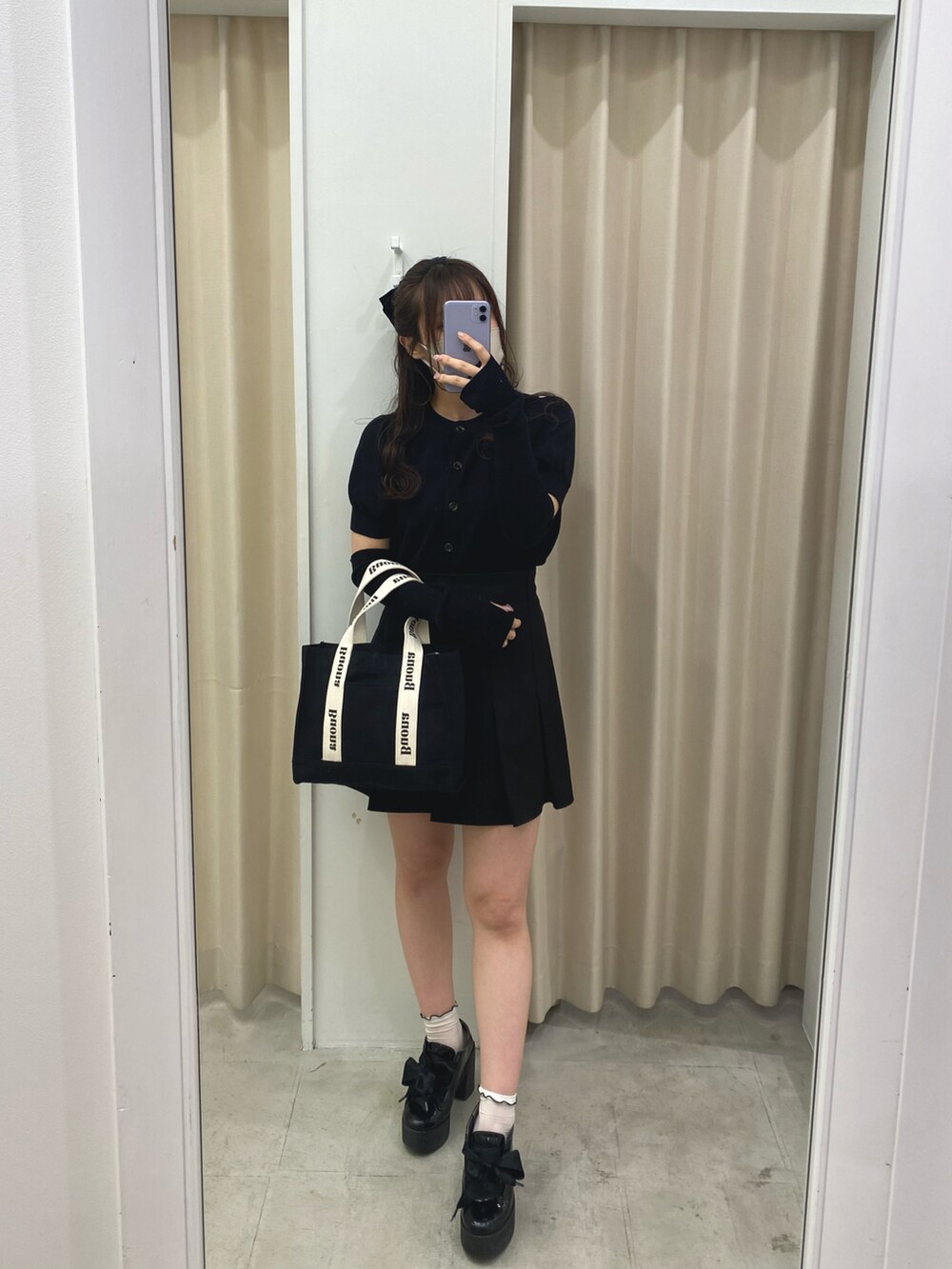 ブラック系のニット/セーター、ブラック系のスカートを着用したレディースの春コーディネートの2枚目の写真