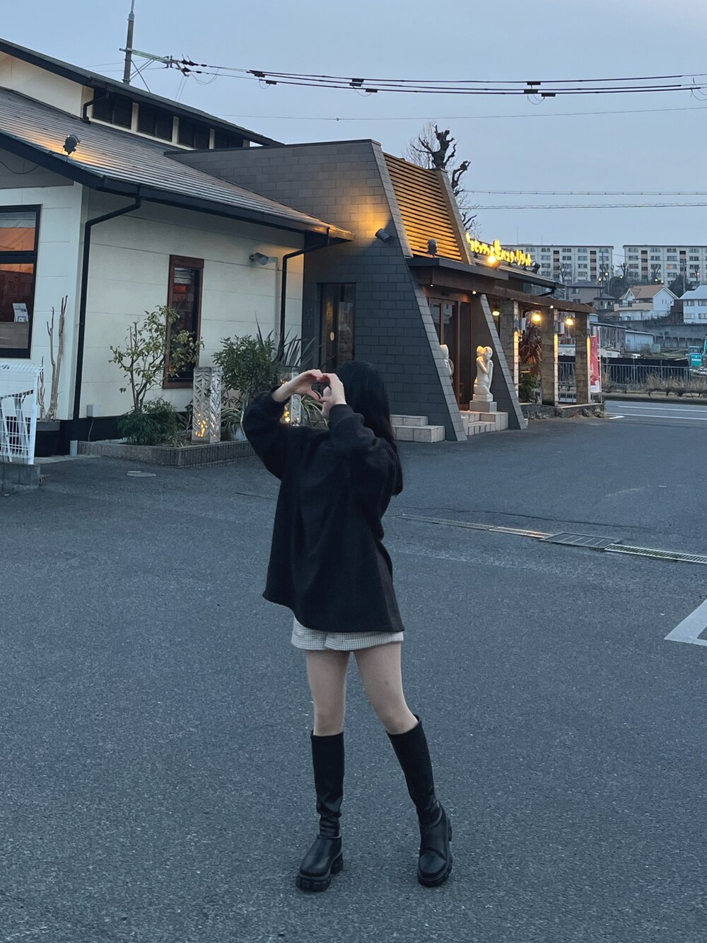 グレー系のトップス、ブラック系のブーツを着用したレディースの春コーディネートの2枚目の写真