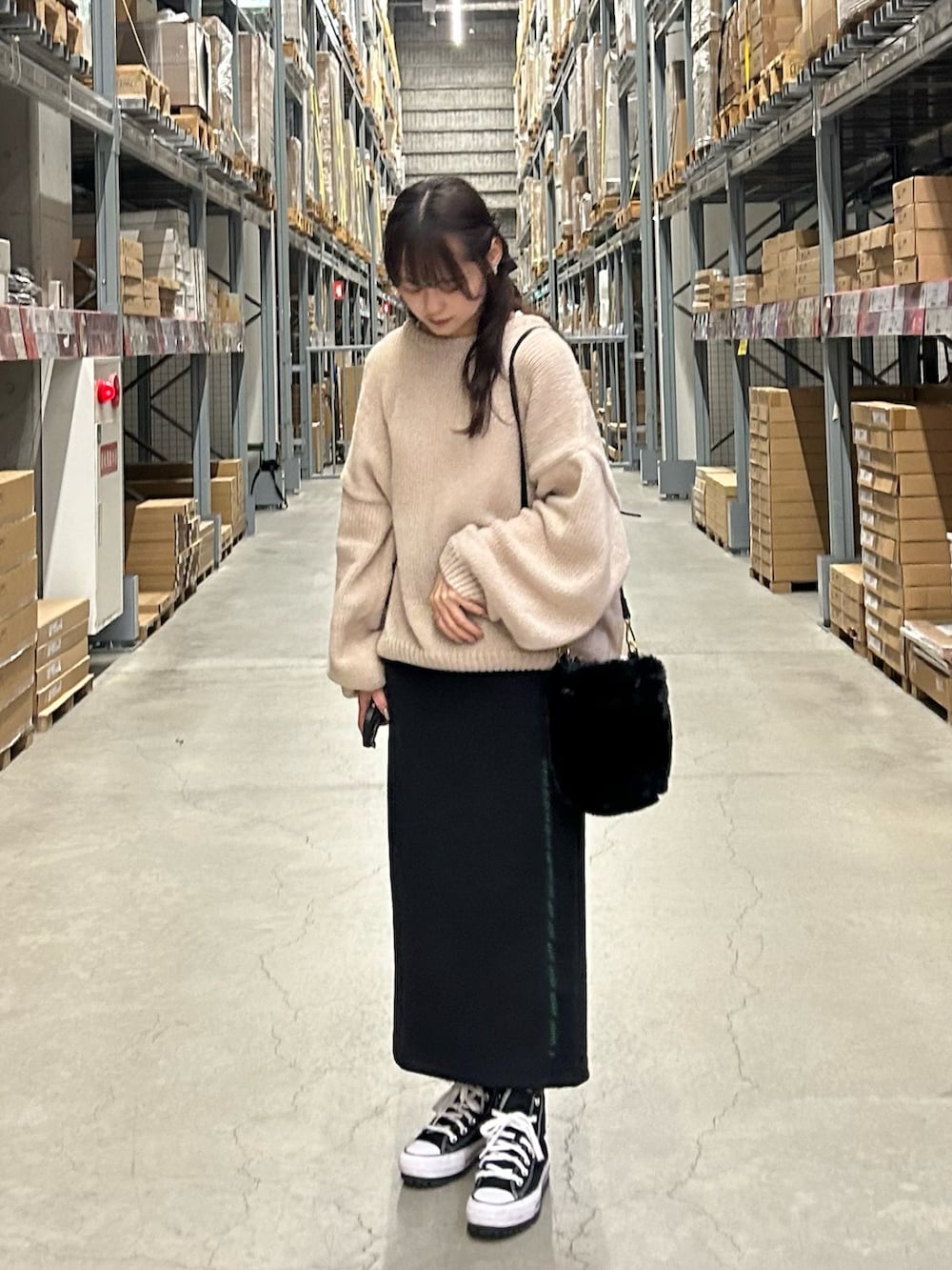 ベージュ系のニット/セーター、ブラック系のハンドバッグ、ブラック系のスカートを着用したレディースの秋コーディネートの2枚目の写真