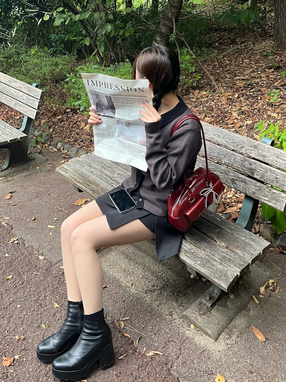 ブラック系のカーディガン/ボレロ、レッド系のショルダーバッグ、ブラック系のスカートを着用したレディースの秋コーディネートの2枚目の写真