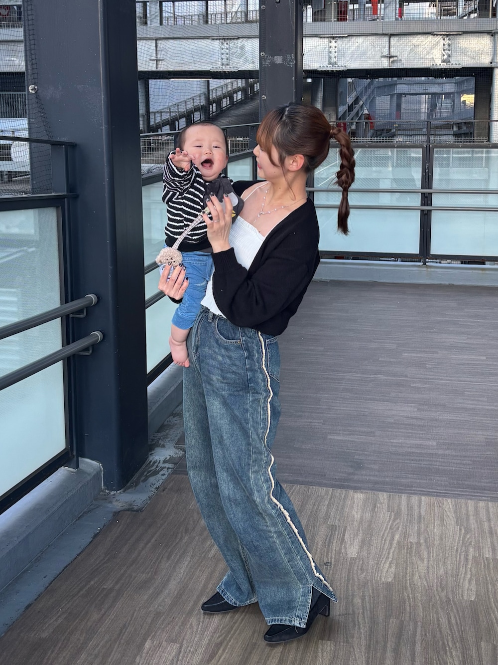 ブルー系のデニムパンツ、ブラック系のパンプス、ブラック系のカーディガン/ボレロを着用したレディースの春コーディネートの2枚目の写真