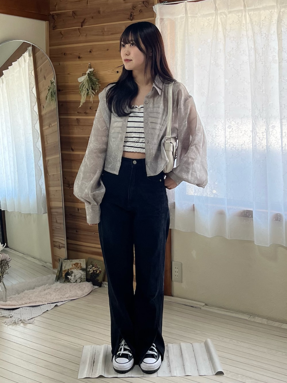 ブラック系のデニムパンツ、ブラック系のスニーカー、グレー系のシャツ/ブラウスを着用したレディースの春コーディネートの2枚目の写真