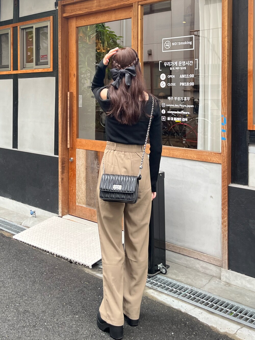 ブラック系のニット/セーター、ブラック系のスラックス、ブラック系のブーツを着用したレディースの冬コーディネートの2枚目の写真