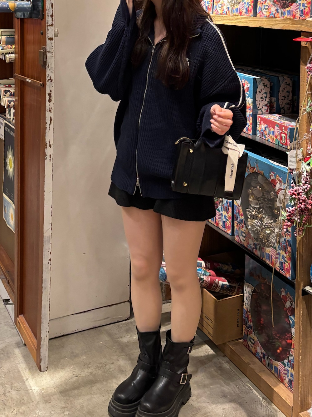 ブルー系のニット/セーター、ブラック系のその他パンツ、ブラック系のブーツを着用したレディースの秋コーディネートの2枚目の写真