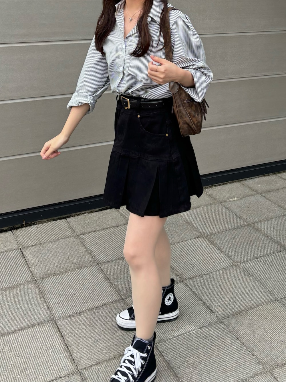 ブラック系のシャツ/ブラウス、ブラック系のデニムスカート、ブラウン系のハンドバッグを着用したレディースの秋コーディネートの2枚目の写真