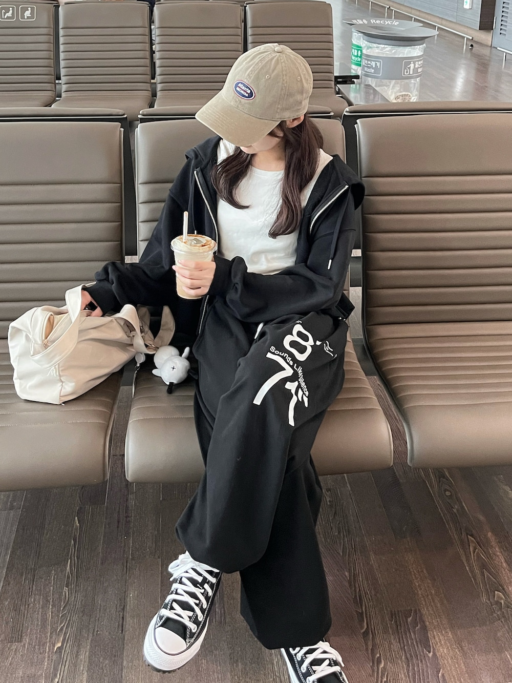 ブラック系のパーカー、ホワイト系のTシャツ/カットソー、ブラック系のパンツを着用したレディースの秋コーディネートの2枚目の写真