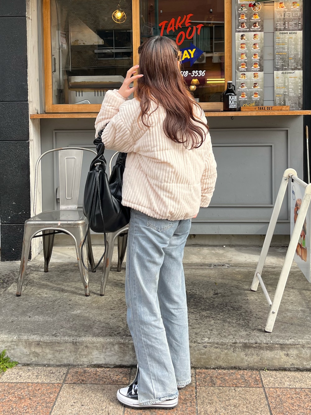 ブルー系のデニムパンツ、ブラック系のスニーカー、ブラック系のバッグを着用したレディースの春コーディネートの2枚目の写真