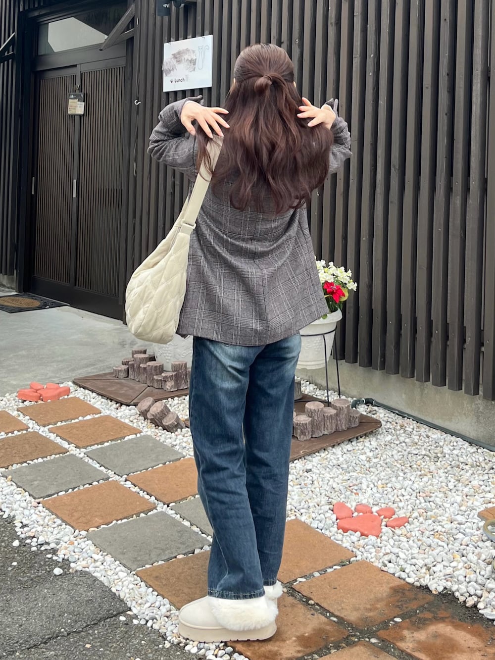 ホワイト系のニット/セーター、ホワイト系のショルダーバッグ、ブルー系のデニムパンツを着用したレディースの冬コーディネートの2枚目の写真