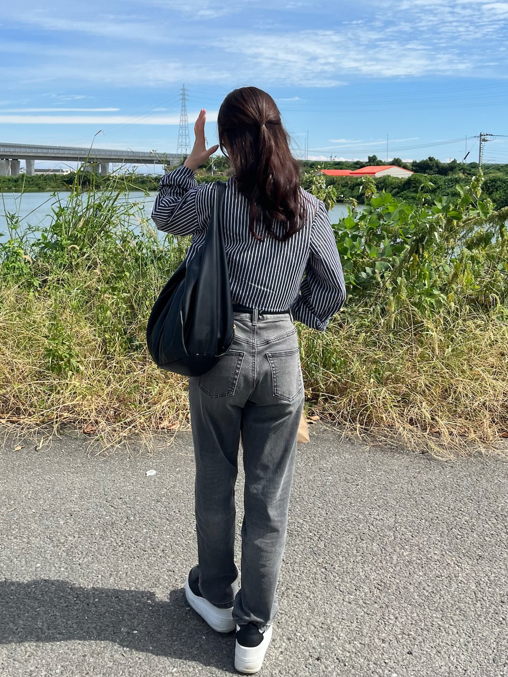 ブラック系のシャツ/ブラウス、ブラック系のバッグ、ブラック系のデニムパンツを着用したレディースの秋コーディネートの2枚目の写真