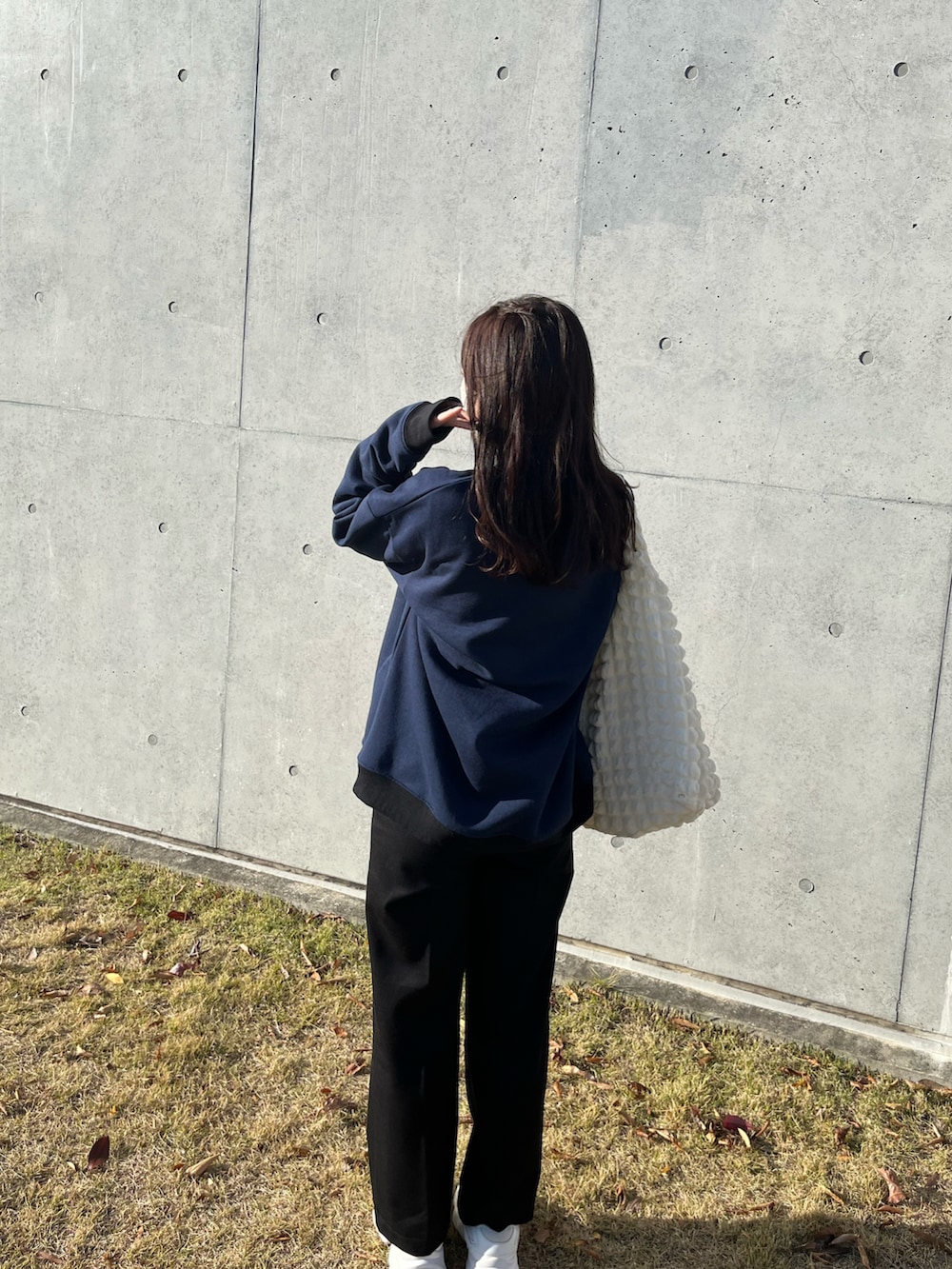 ブルー系のスウェット、ホワイト系のトートバッグ、ブラック系のその他パンツを着用したレディースの冬コーディネートの2枚目の写真