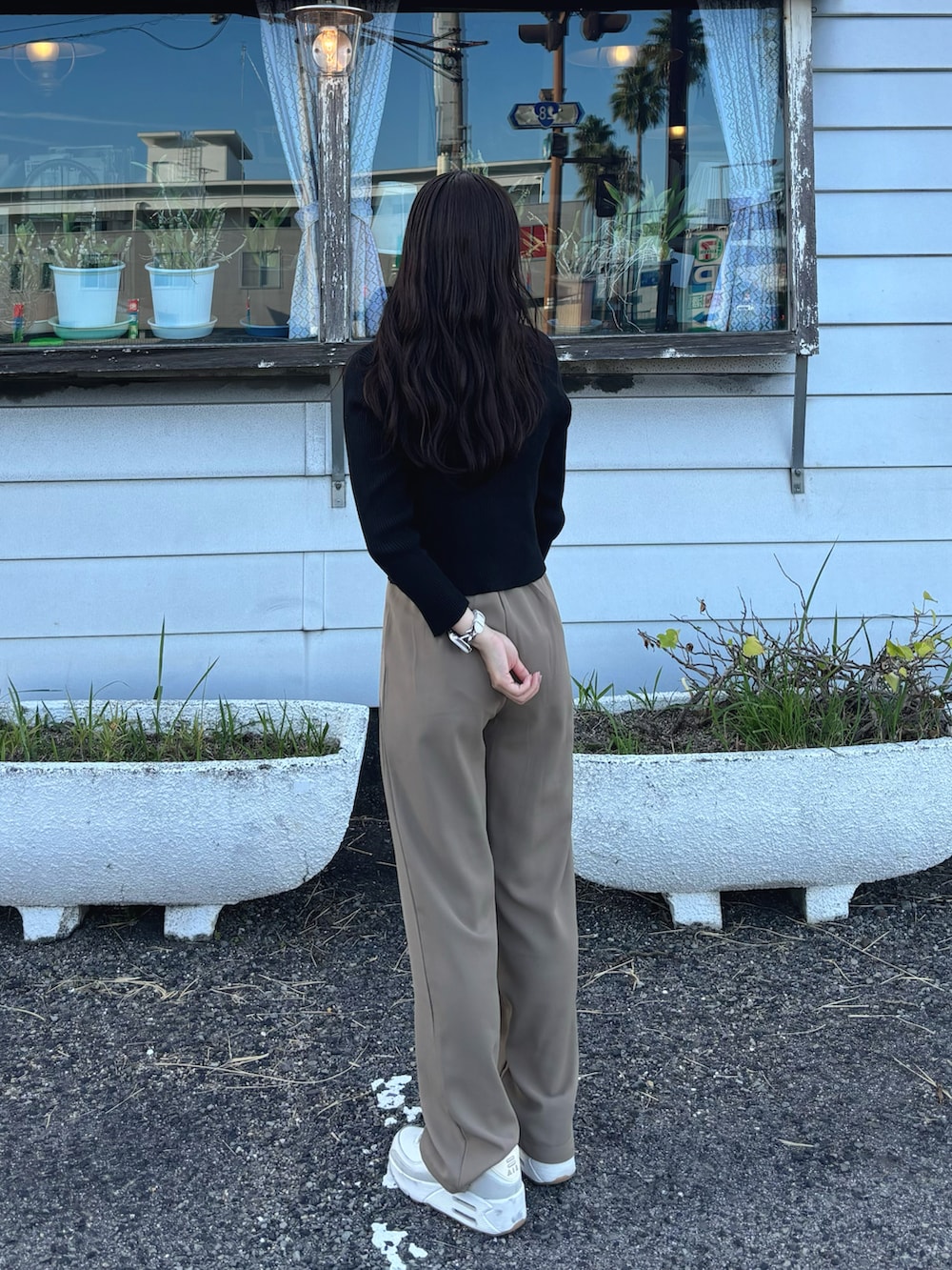 ブラック系のニット/セーター、ブラック系のショルダーバッグ、ブラック系のスラックスを着用したレディースの秋コーディネートの2枚目の写真