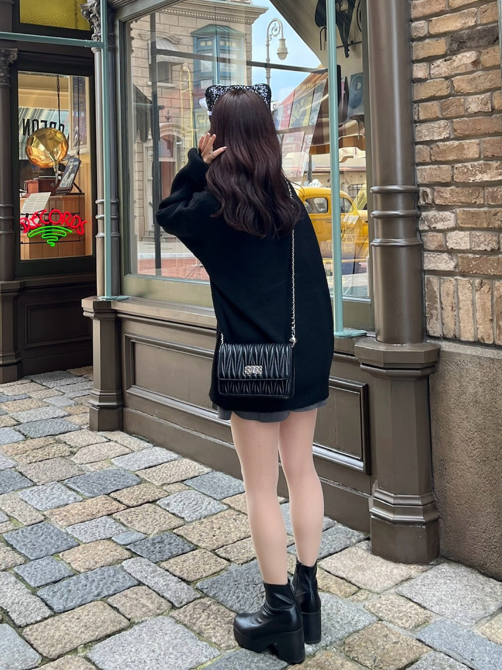 ブラック系のニット/セーター、グレー系のスカート、ホワイト系のブーツを着用したレディースの冬コーディネートの2枚目の写真