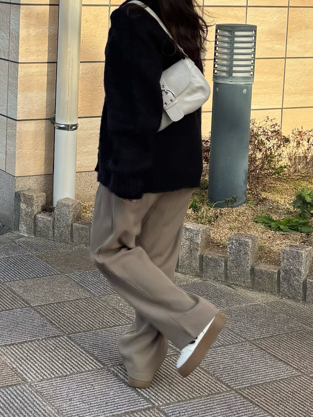 ブラック系のカーディガン/ボレロ、ベージュ系のショルダーバッグ、ブラック系のスラックスを着用したレディースの秋コーディネートの2枚目の写真
