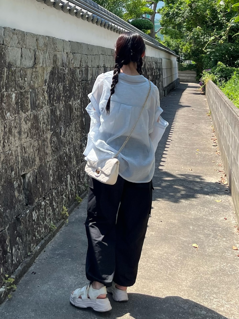 ブラック系のカーゴパンツ、ベージュ系のタンクトップ、ブルー系のシャツ/ブラウスを着用したレディースの夏コーディネートの2枚目の写真