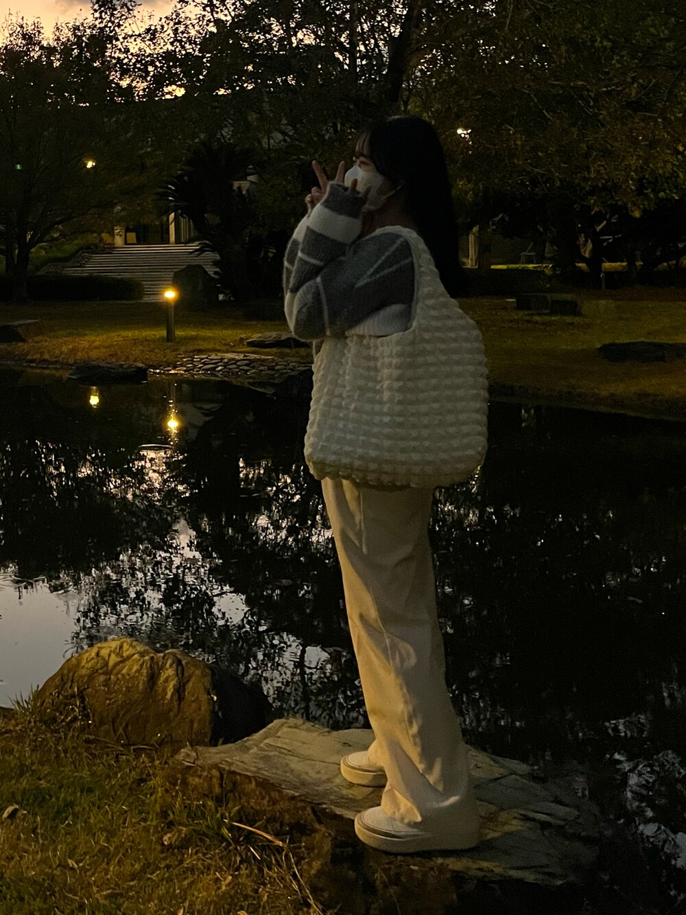 ホワイト系のスラックス、ホワイト系のスニーカー、ホワイト系のトートバッグを着用したレディースの秋コーディネートの2枚目の写真