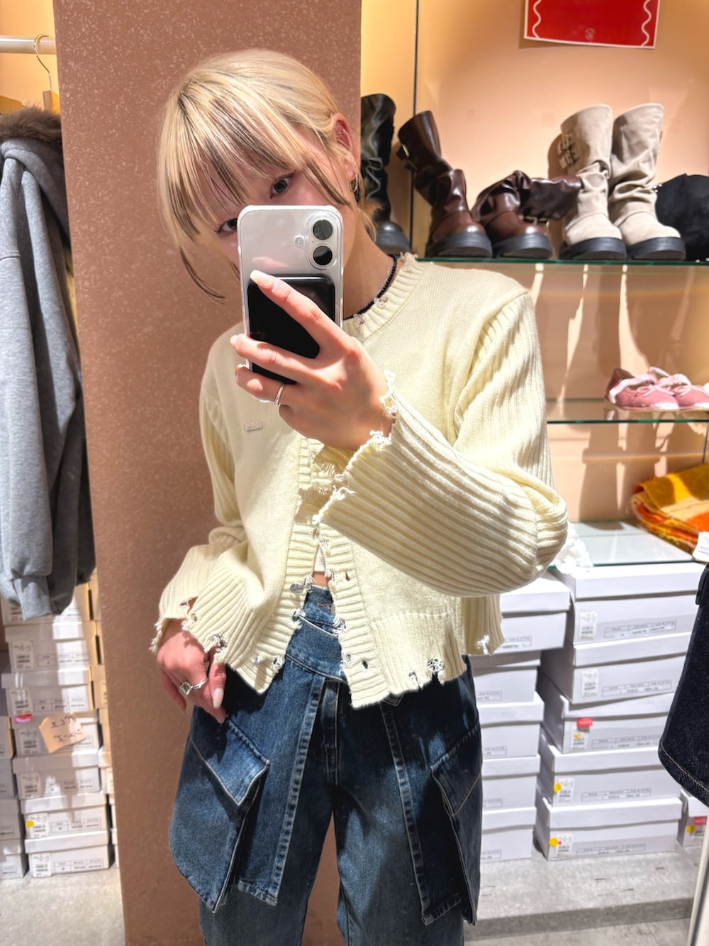ホワイト系のカーディガン/ボレロ、ブルー系のデニムパンツを着用したレディースの春コーディネートの2枚目の写真
