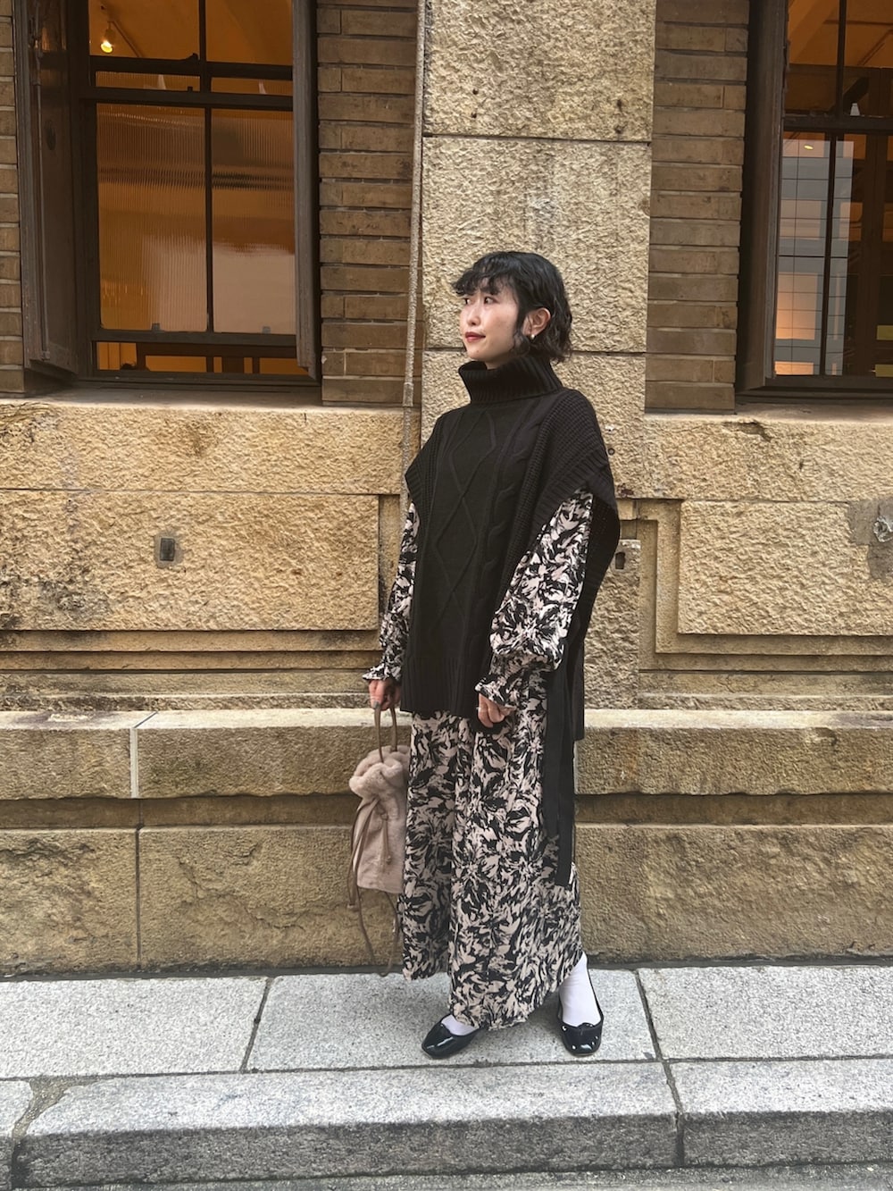 ブラック系のベスト、ブラック系のワンピース/ドレス、ブラウン系のショルダーバッグを着用したレディースの秋コーディネートの3枚目の写真