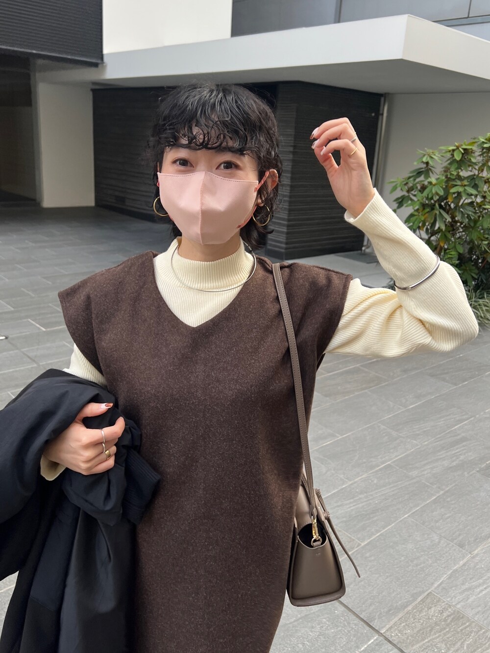 ブラウン系のワンピース、ブラウン系のショルダーバッグ、ブラック系のブルゾンを着用したレディースの秋コーディネートの3枚目の写真