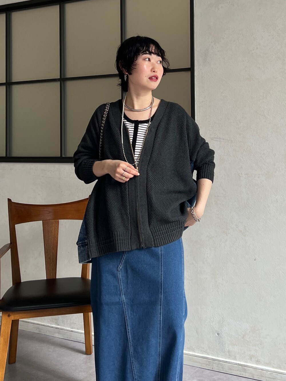 グレー系のカーディガン/ボレロ、ホワイト系のキャミソール、ブルー系のスカートを着用したレディースの冬コーディネートの5枚目の写真