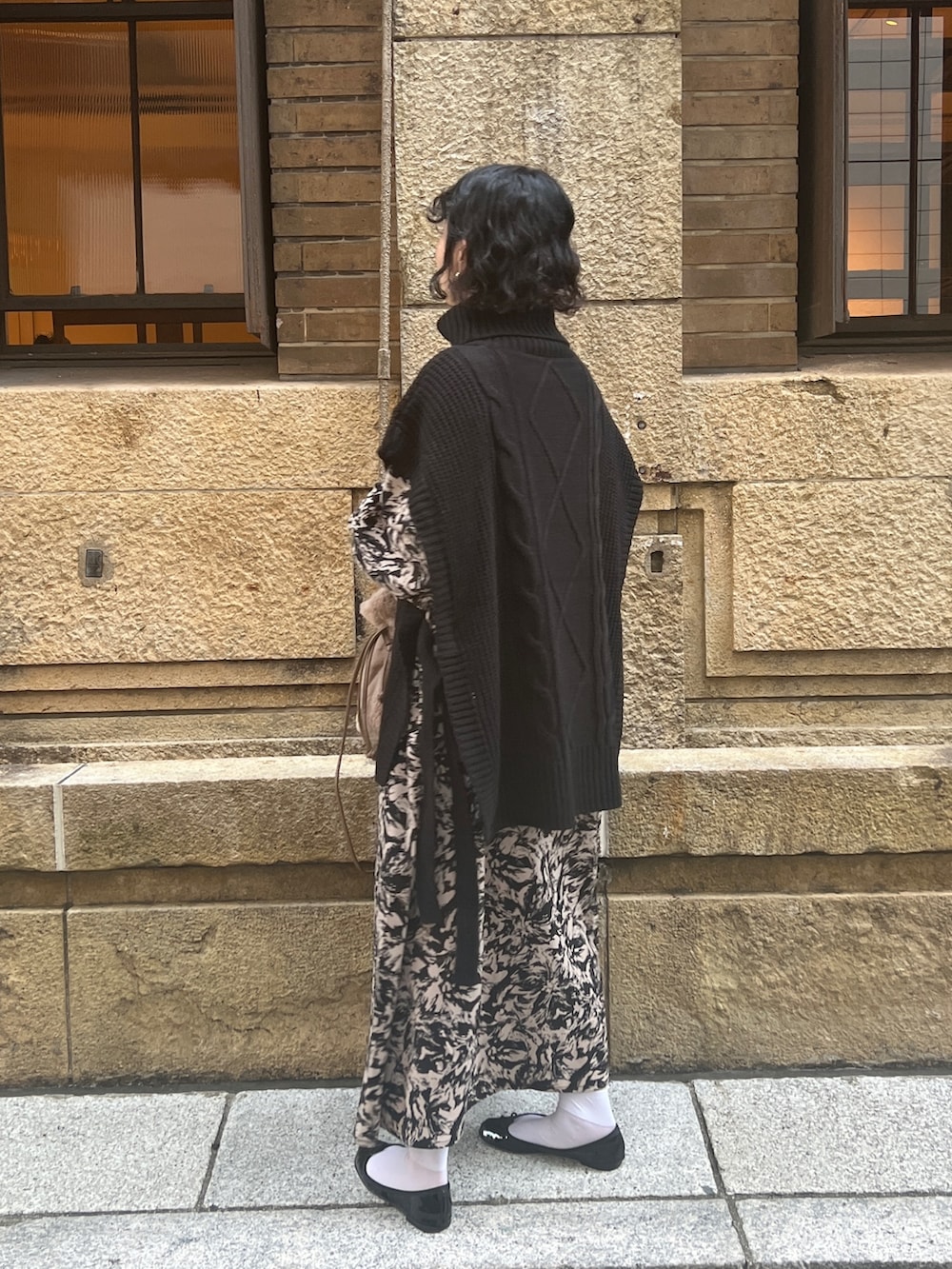 ブラック系のベスト、ブラック系のワンピース/ドレス、ブラウン系のショルダーバッグを着用したレディースの秋コーディネートの4枚目の写真