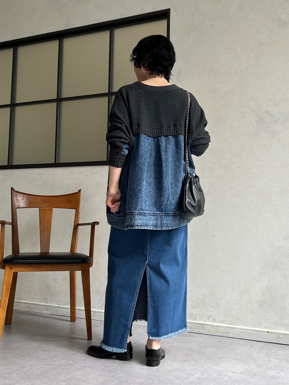 グレー系のカーディガン/ボレロ、ホワイト系のキャミソール、ブルー系のスカートを着用したレディースの冬コーディネートの2枚目の写真