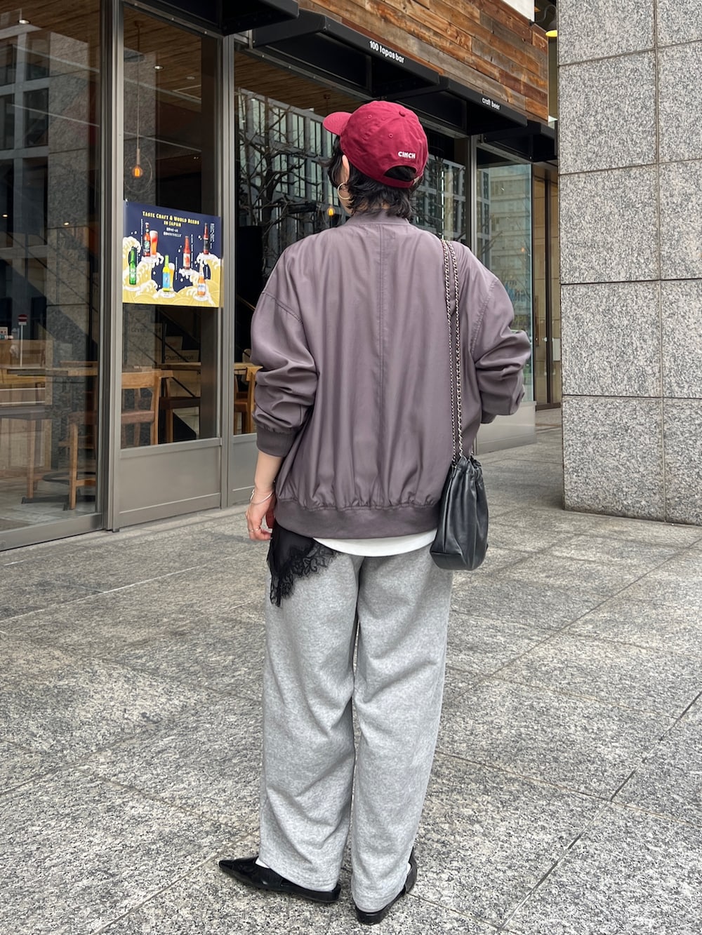 グレー系のブルゾン、ホワイト系のTシャツ/カットソー、グレー系のその他パンツを着用したレディースの春コーディネートの2枚目の写真