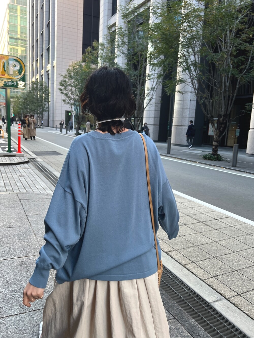 ブルー系のニット/セーター、ホワイト系のスカート、シルバー系のバレエシューズを着用したレディースの春コーディネートの4枚目の写真
