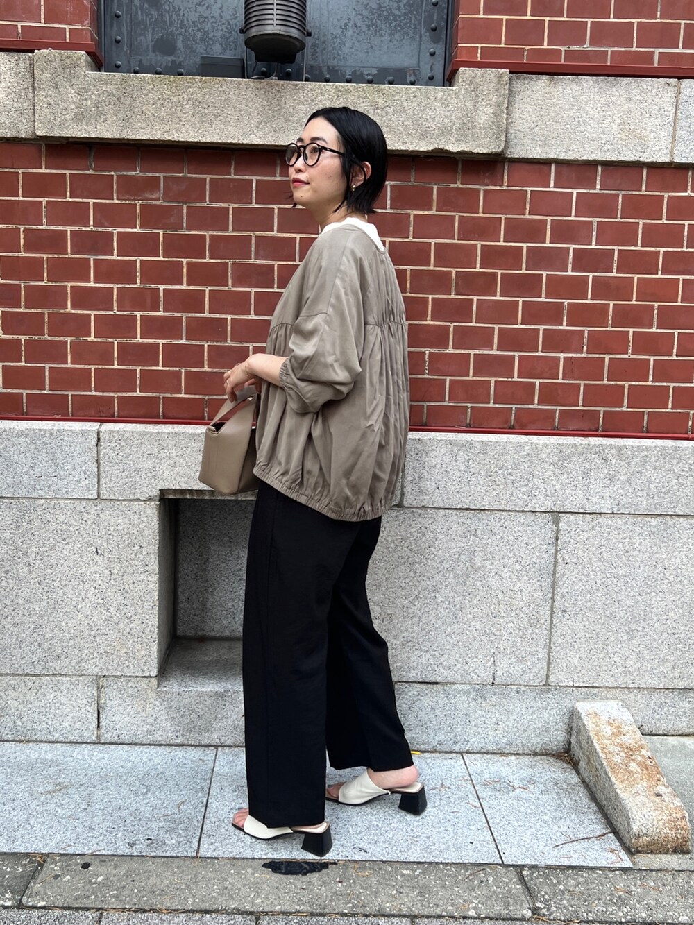 ブラック系のその他パンツ、グリーン系のブルゾン、ホワイト系のベストを着用したレディースの夏コーディネートの3枚目の写真