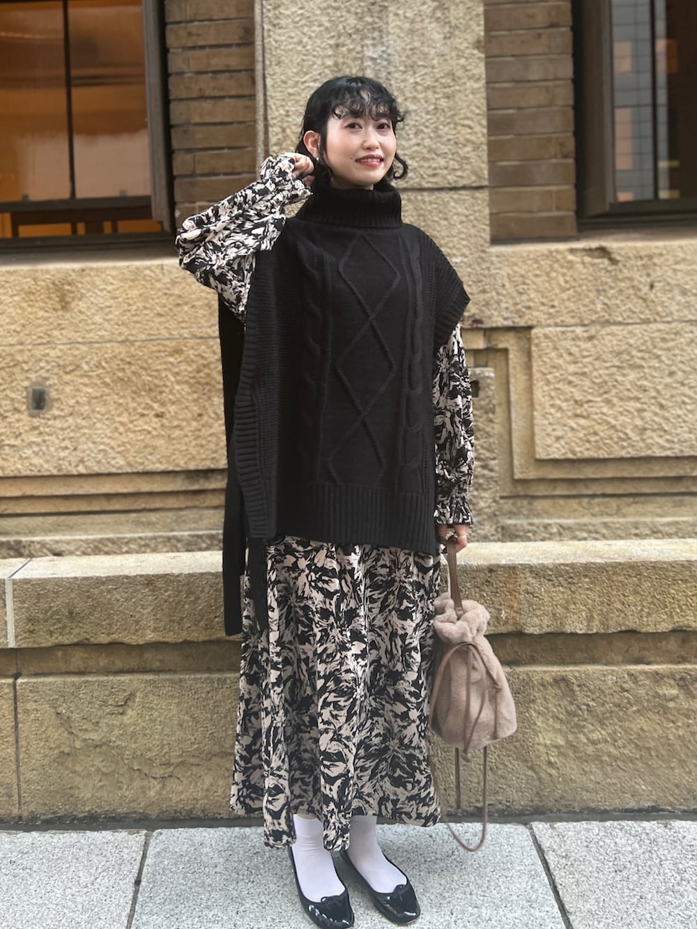 ブラック系のベスト、ブラック系のワンピース/ドレス、ブラウン系のショルダーバッグを着用したレディースの秋コーディネートの2枚目の写真