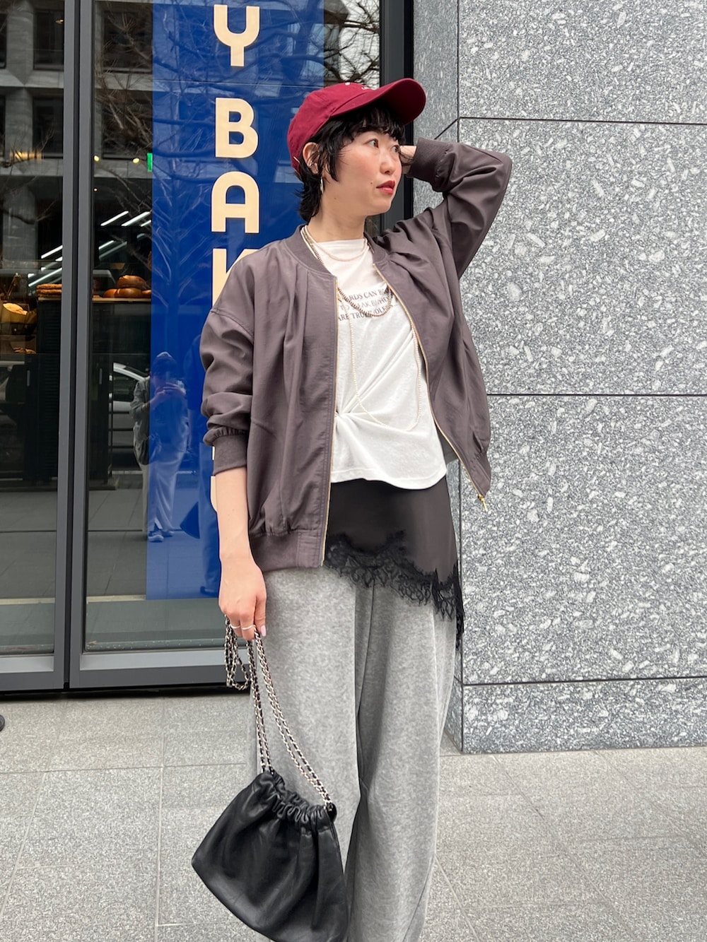 グレー系のブルゾン、ホワイト系のTシャツ/カットソー、グレー系のその他パンツを着用したレディースの春コーディネートの3枚目の写真