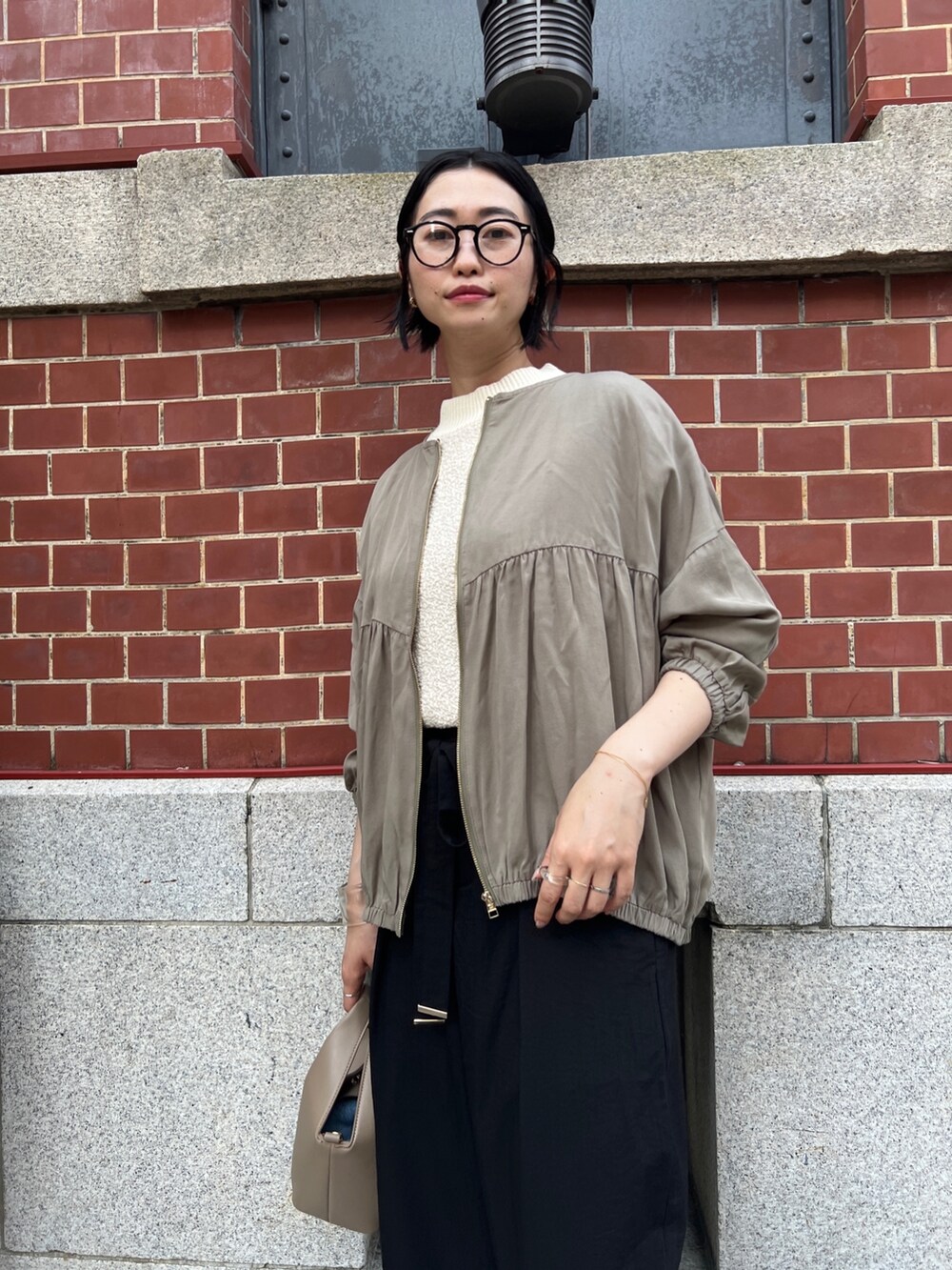 ブラック系のその他パンツ、グリーン系のブルゾン、ホワイト系のベストを着用したレディースの夏コーディネートの2枚目の写真