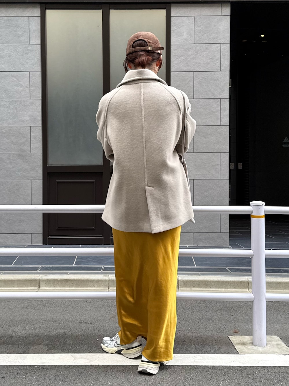 ベージュ系のピーコート、グレー系のニット/セーター、シルバー系のスニーカーを着用したレディースの秋コーディネートの3枚目の写真