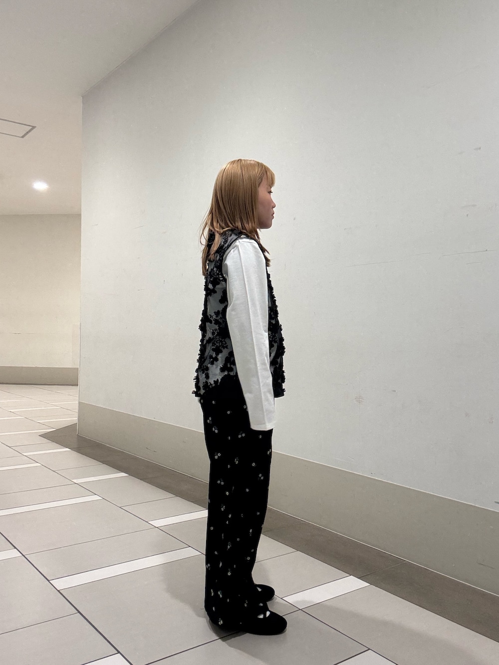 ホワイト系のTシャツ/カットソー、ブラック系のタンクトップ、ブラック系のスニーカーを着用したレディースの春コーディネートの3枚目の写真