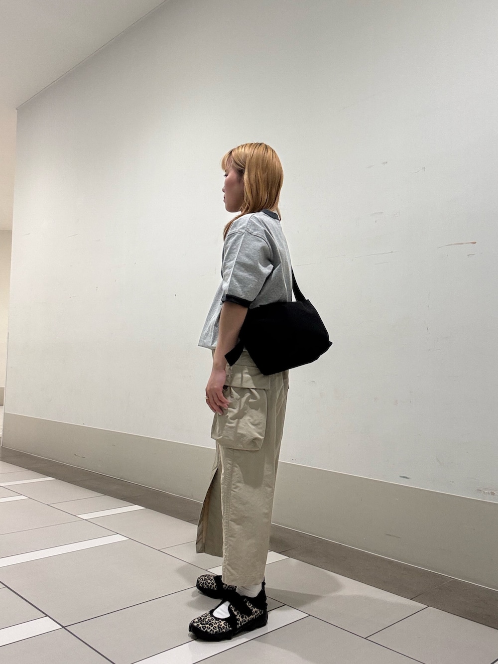 ベージュ系のスカート、グレー系のTシャツ/カットソー、その他のスニーカーを着用したレディースの春コーディネートの3枚目の写真