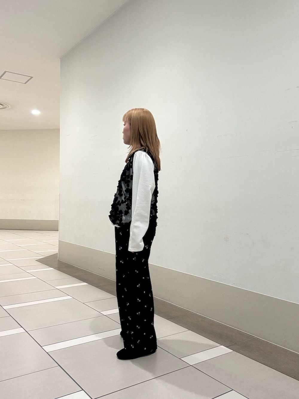 ホワイト系のTシャツ/カットソー、ブラック系のタンクトップ、ブラック系のスニーカーを着用したレディースの春コーディネートの2枚目の写真