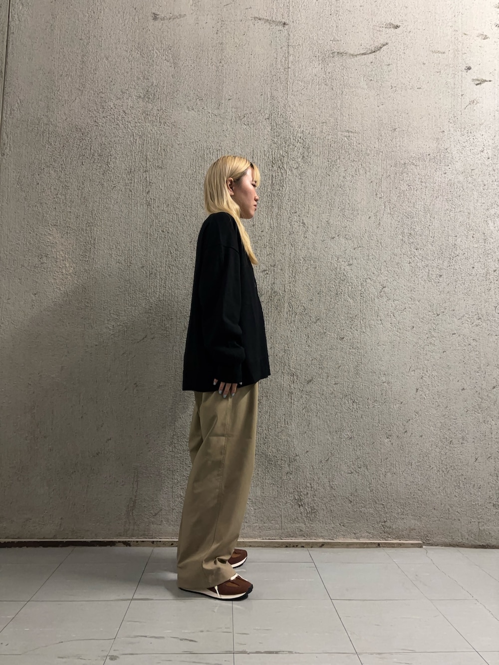 ブラック系のカーディガン/ボレロ、ブラウン系のスニーカー、ホワイト系のTシャツ/カットソーを着用したレディースの秋コーディネートの2枚目の写真