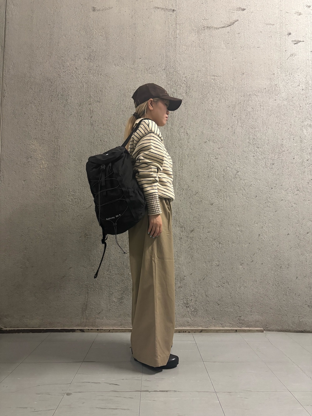 ベージュ系のその他パンツ、ブラック系のその他シューズ、ホワイト系のニット/セーターを着用したレディースの秋コーディネートの2枚目の写真