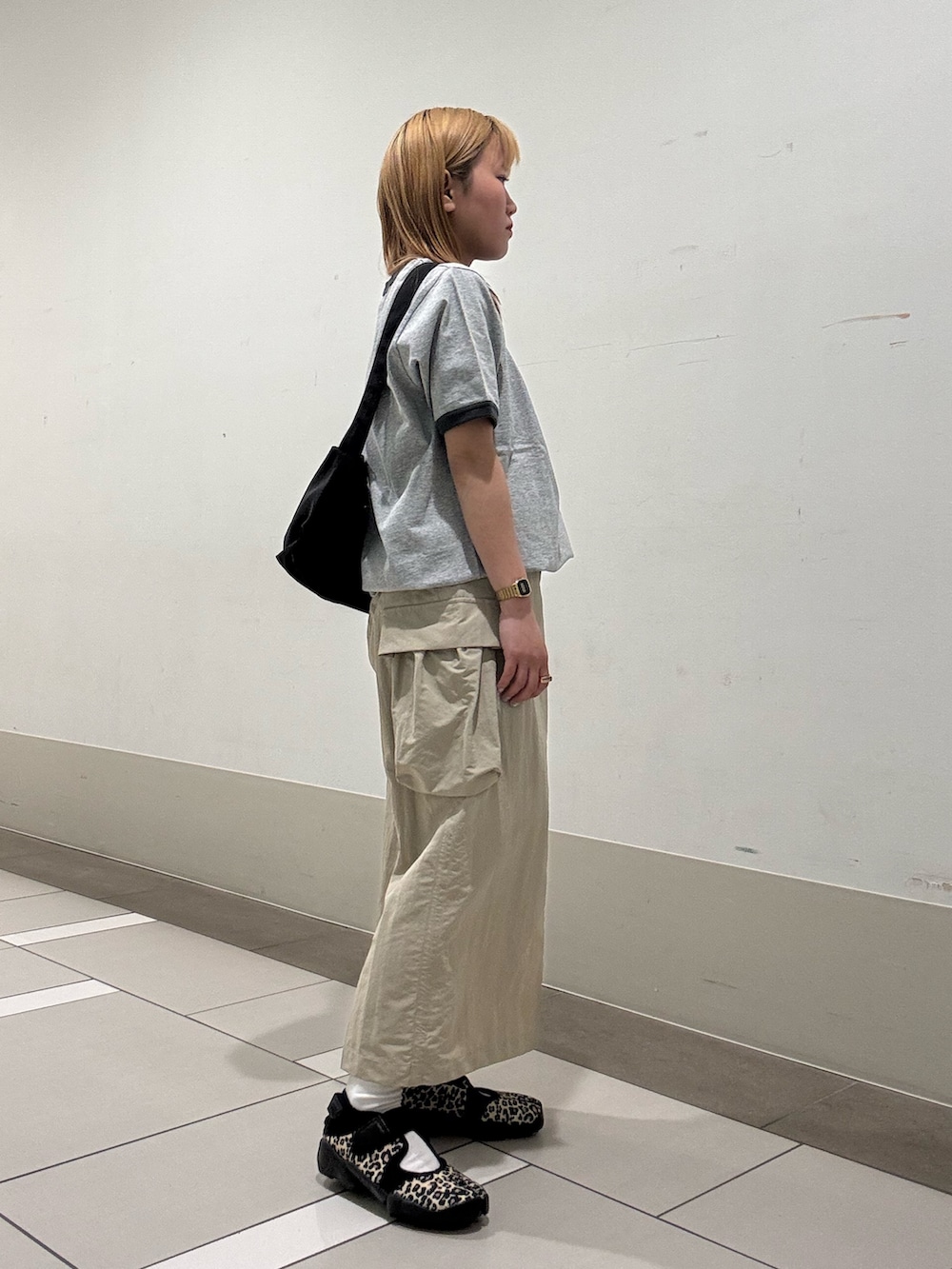 ベージュ系のスカート、グレー系のTシャツ/カットソー、その他のスニーカーを着用したレディースの春コーディネートの2枚目の写真