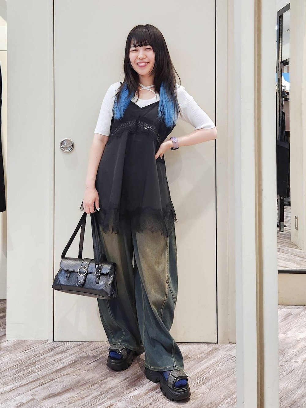 ブラック系のキャミソール、グリーン系のデニムパンツ、グレー系のサンダルを着用したレディースの秋コーディネートの6枚目の写真