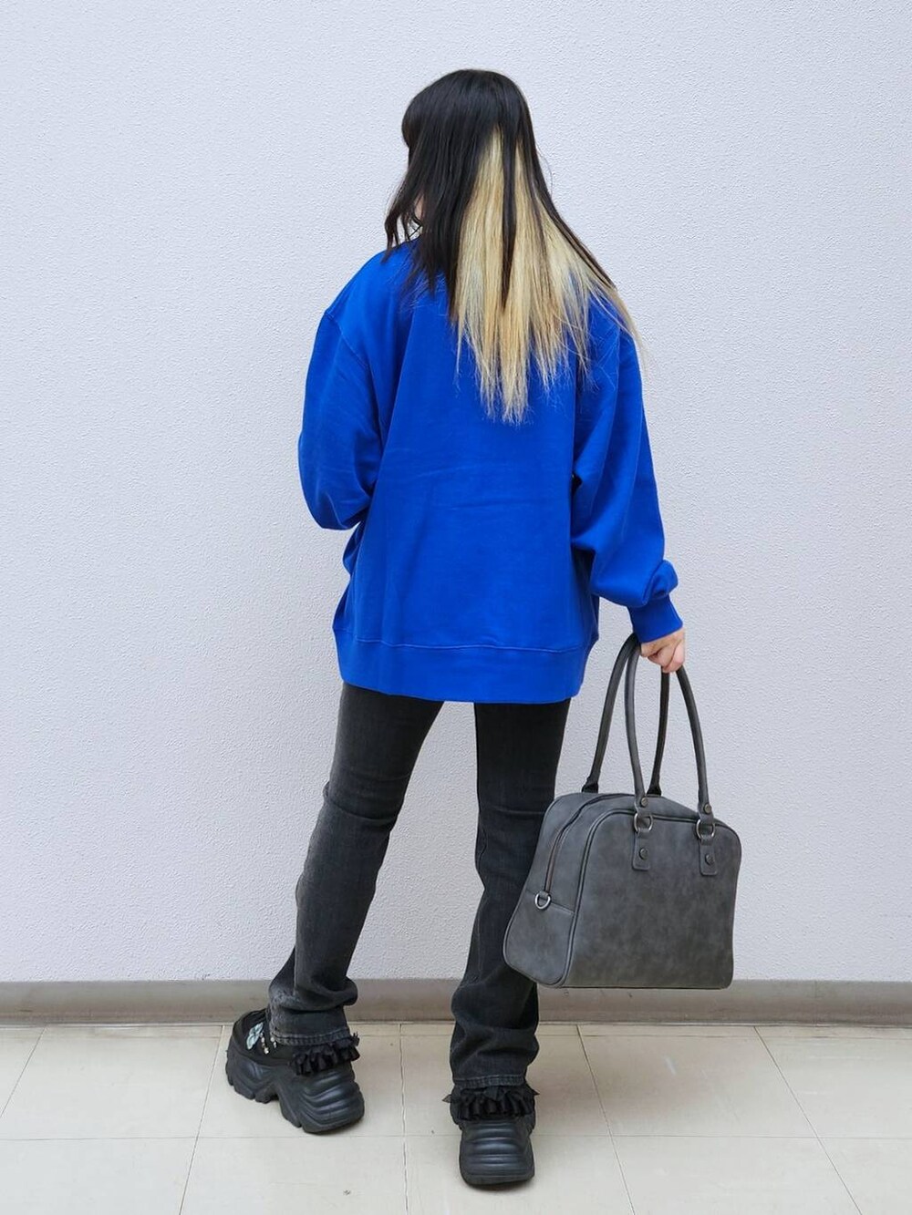 ブラック系のデニムパンツ、グレー系のボストンバッグ、ブルー系のTシャツ/カットソーを着用したレディースの秋コーディネートの4枚目の写真