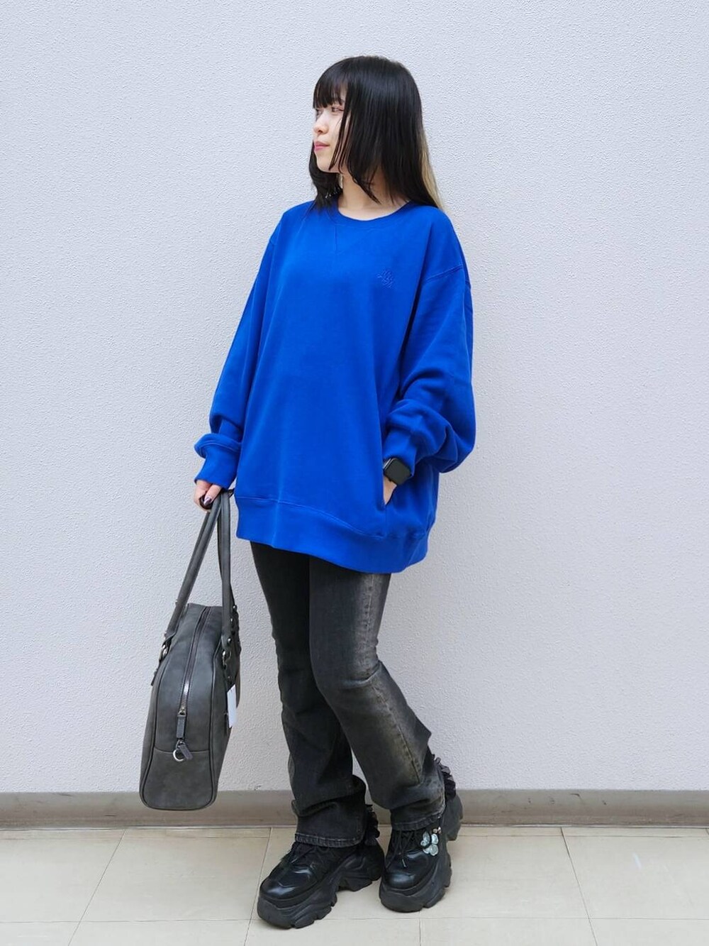 ブラック系のデニムパンツ、グレー系のボストンバッグ、ブルー系のTシャツ/カットソーを着用したレディースの秋コーディネートの6枚目の写真