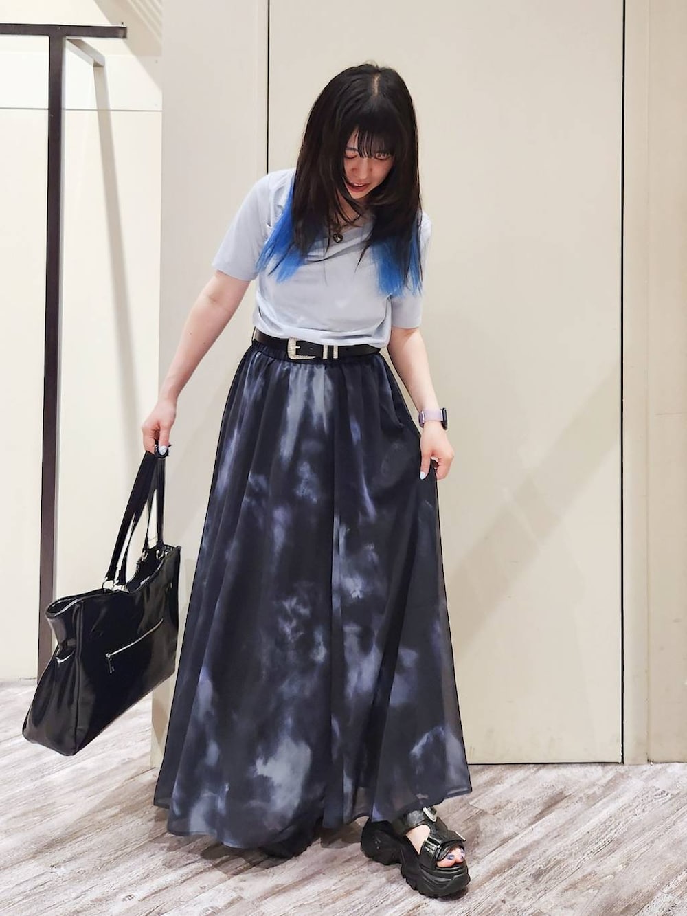 ブラック系のスカート、ブラック系のサンダル、グレー系のTシャツ/カットソーを着用したレディースの秋コーディネートの2枚目の写真