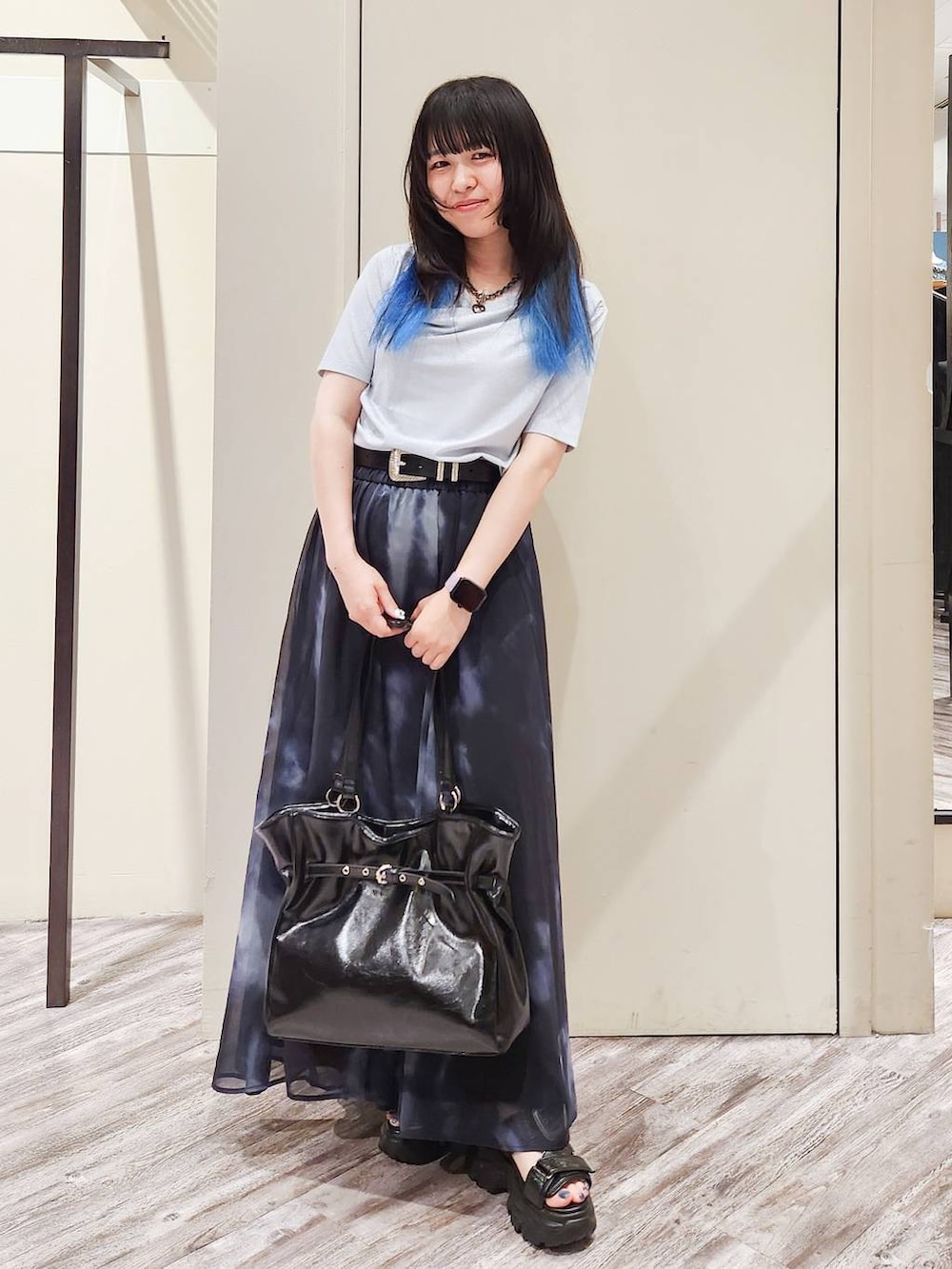 ブラック系のスカート、ブラック系のサンダル、グレー系のTシャツ/カットソーを着用したレディースの秋コーディネートの7枚目の写真