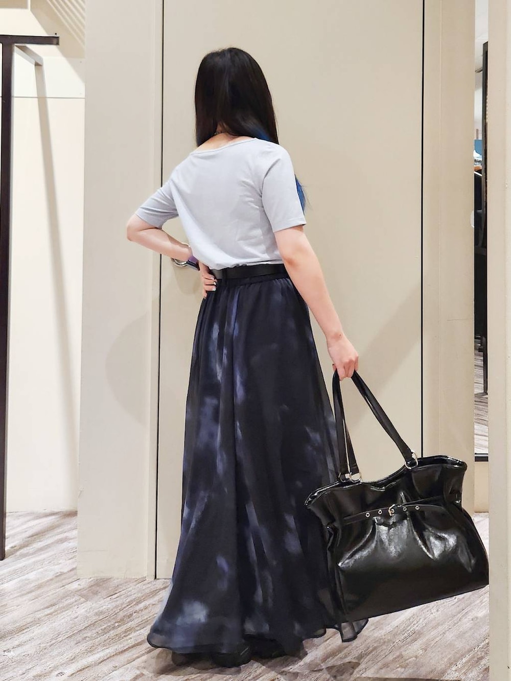 ブラック系のスカート、ブラック系のサンダル、グレー系のTシャツ/カットソーを着用したレディースの秋コーディネートの3枚目の写真