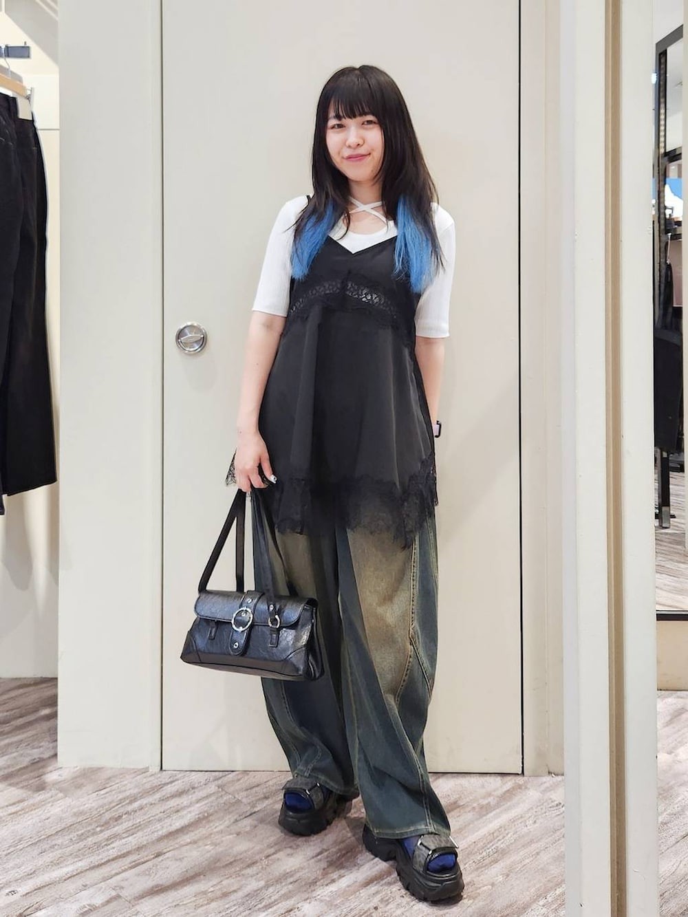ブラック系のキャミソール、グリーン系のデニムパンツ、グレー系のサンダルを着用したレディースの秋コーディネートの2枚目の写真