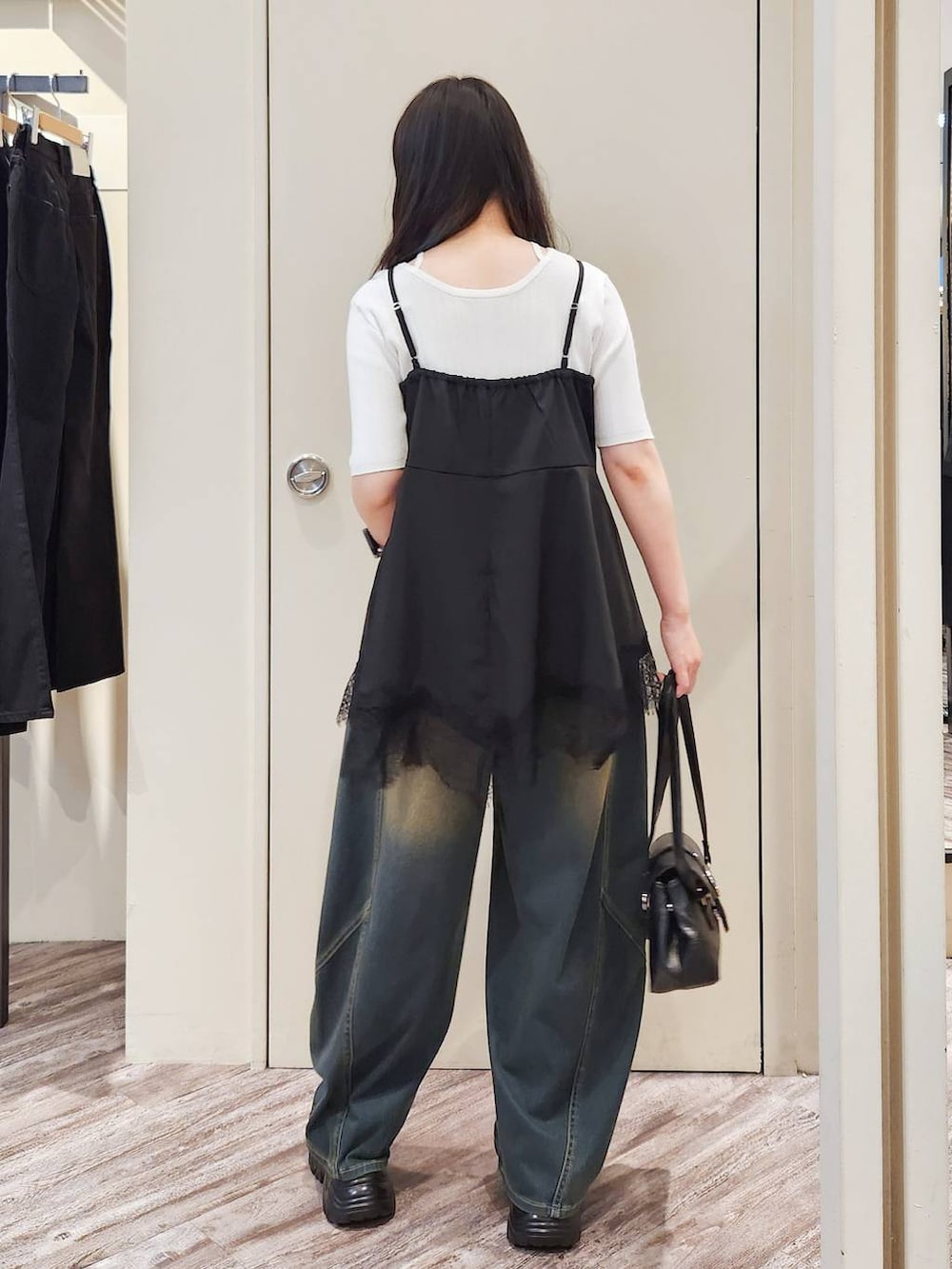 ブラック系のキャミソール、グリーン系のデニムパンツ、グレー系のサンダルを着用したレディースの秋コーディネートの4枚目の写真