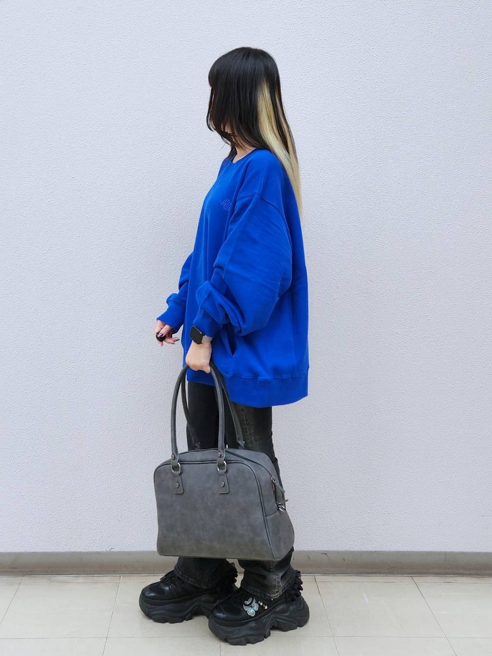 ブラック系のデニムパンツ、グレー系のボストンバッグ、ブルー系のTシャツ/カットソーを着用したレディースの秋コーディネートの5枚目の写真
